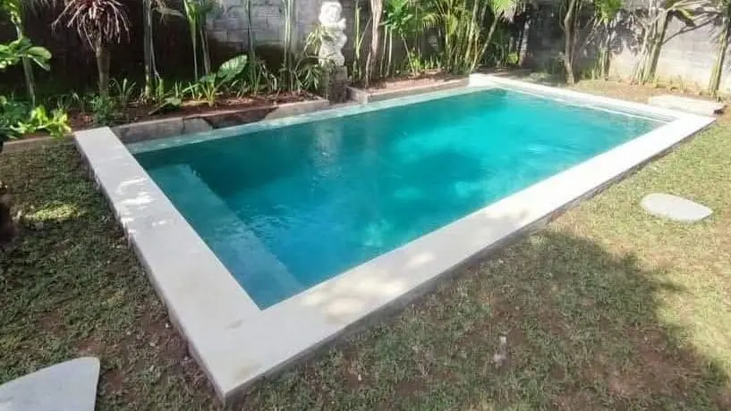 Garden pool with light stone coping set in a lawn