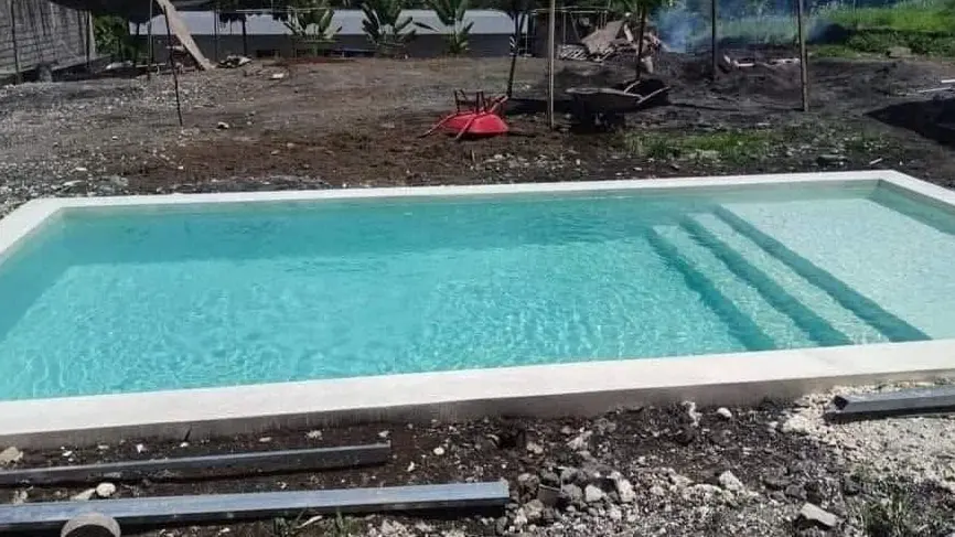 Newly built pool with entry steps, ready to be filled, on a site in Badung