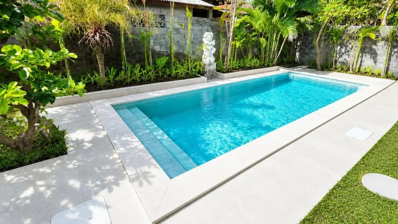 Completed swimming pool with light stone coping in a tropical garden in Seseh, Bali