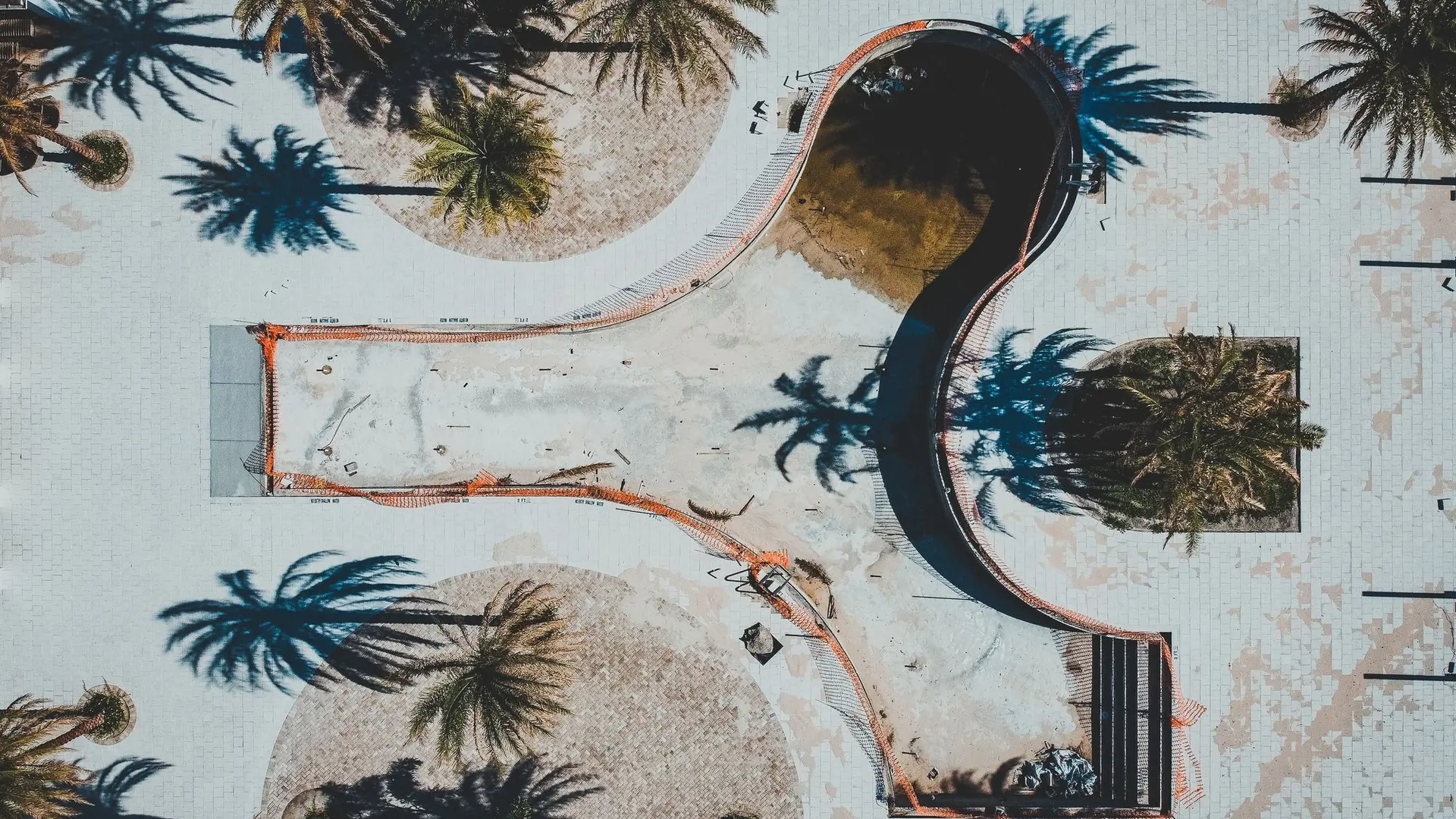 Illustrative aerial view of an empty pool fenced off for renovation work